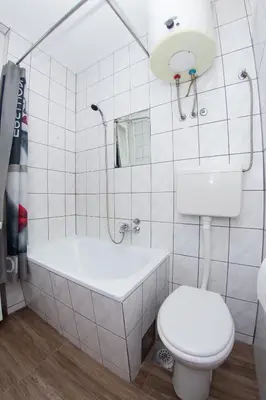 a white bathroom with a tub and a toilet at Apartment Kalemegdan in Belgrade