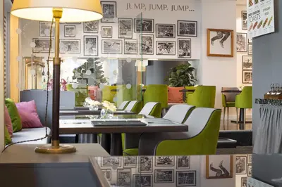 a dining room with a table and green chairs at Jump INN Hotel Belgrade in Belgrade