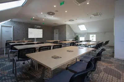 a classroom with tables and chairs and a whiteboard at Jump INN Hotel Belgrade in Belgrade