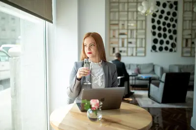 a woman sitting at a table with a laptop at Jump INN Hotel Belgrade in Belgrade