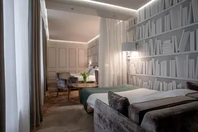 a hotel room with a bed and a couch and a desk at Jump INN Hotel Belgrade in Belgrade