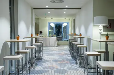 a row of tables and stools in a room at Jump INN Hotel Belgrade in Belgrade