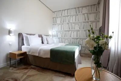 a hotel room with a bed and a vase of flowers at Jump INN Hotel Belgrade in Belgrade