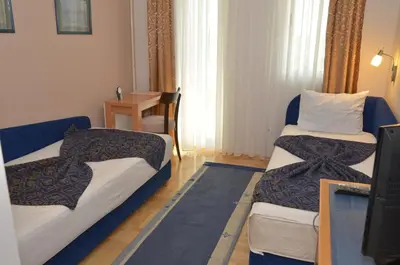 a hotel room with two beds and a television at Hotel Dragović Smederevo in Smederevo