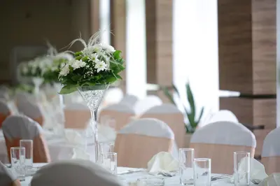 a table with a vase filled with flowers on it at Hotel Dragović Smederevo in Smederevo