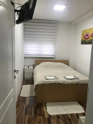 a small bedroom with a bed and a window at Apartman Bazar in Smederevo