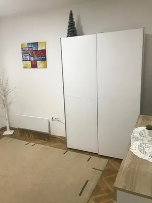 a white cabinet in a room with a christmas tree on the wall at Apartman Bazar in Smederevo