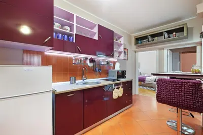 a kitchen with purple cabinets and a white refrigerator at Sava SQUARE Apartment in Belgrade