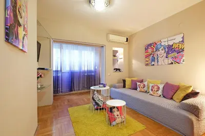 a living room with a couch and a painting on the wall at Sava SQUARE Apartment in Belgrade