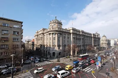 a large building with cars parked in front of it at Sava SQUARE Apartment in Belgrade
