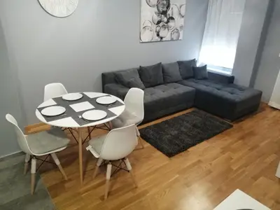 a living room with a couch and a table and chairs at FIT apartman in Belgrade