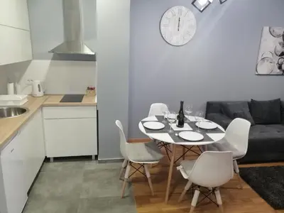 a kitchen and dining room with a table and chairs at FIT apartman in Belgrade