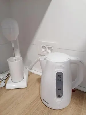 a white blender sitting on a table next to a lamp at FIT apartman in Belgrade