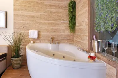 a white bath tub in a bathroom with a wall at Central SPA Galaxy Apartment in Belgrade