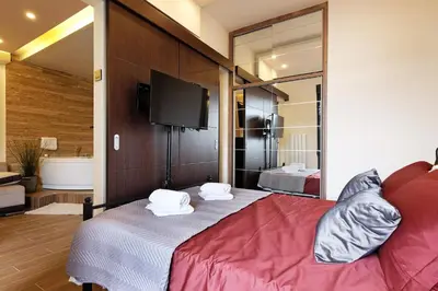 a bedroom with two beds and a flat screen tv at Central SPA Galaxy Apartment in Belgrade