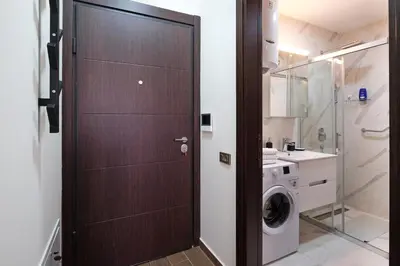 a brown door in a bathroom with a washing machine at Central SPA Galaxy Apartment in Belgrade