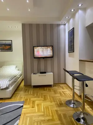 a bedroom with a bed and a tv on the wall at Cika Ljuba in Belgrade