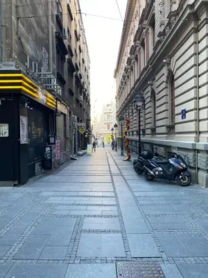 an empty city street with two motorcycles parked next to buildings at Cika Ljuba in Belgrade