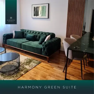 a green couch in a living room with a table at Harmony Apartmani Arandjelovac in Arandjelovac