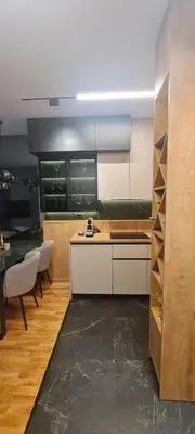 a kitchen with a counter and a table with chairs at Harmony Apartmani Arandjelovac in Arandjelovac