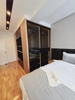 a bedroom with a large bed and a closet at Harmony Apartmani Arandjelovac in Arandjelovac