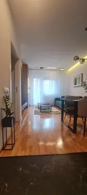 a living room with a table and a couch at Harmony Apartmani Arandjelovac in Arandjelovac