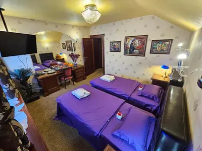 a room with two purple beds and a desk at Vila Geppetto in Belgrade
