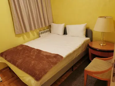 a bedroom with a bed with white sheets and a window at Contigo Apartments in Belgrade