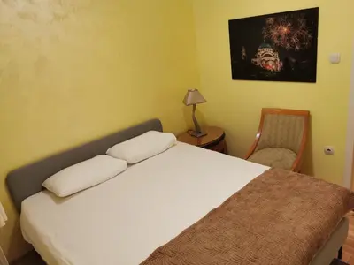 a bedroom with a bed and a lamp and a chair at Contigo Apartments in Belgrade