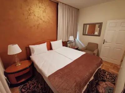 a bedroom with a bed and a chair and a mirror at Contigo Apartments in Belgrade