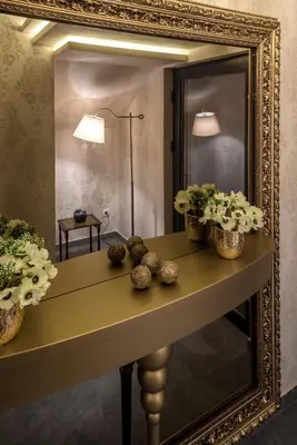 a mirror on a table with flowers on it at Belly3 in Belgrade
