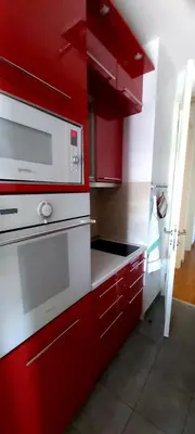a kitchen with red cabinets and a microwave at Apartman Tea Belville in Belgrade