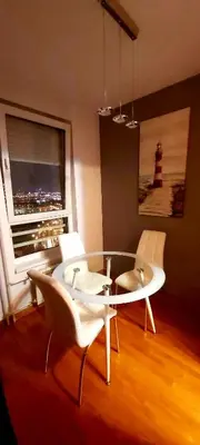a dining room with a table and white chairs at Apartman Tea Belville in Belgrade