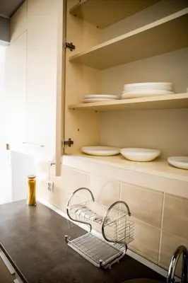 a chair in a kitchen with plates on shelves at Apartman Tea Belville in Belgrade