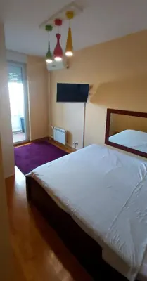 a bedroom with a large white bed and a window at Apartman Tea Belville in Belgrade
