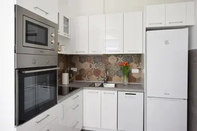 a white kitchen with white cabinets and a microwave at Crown apartment - Your most comfortable stay in Belgrade