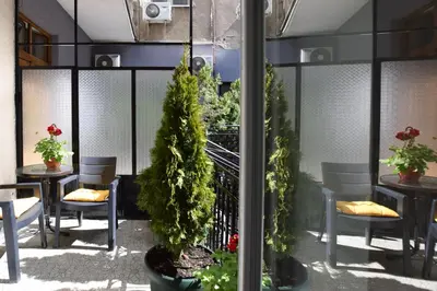 a dining room with tables and chairs and trees at Crown apartment - Your most comfortable stay in Belgrade