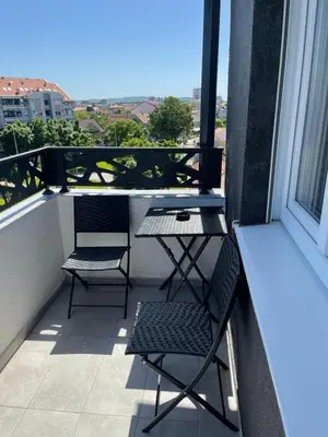 a balcony with two chairs and a table on a balcony at Royal Residence Apartmani 2 in Pančevo