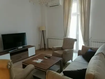 a living room with a couch and chairs and a television at Beograd centar in Belgrade