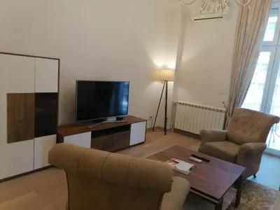 a living room with a couch and a tv and chairs at Beograd centar in Belgrade