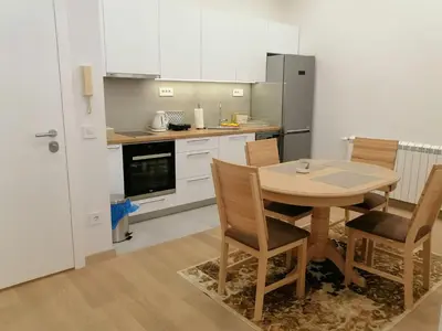 a kitchen with a table and chairs and a refrigerator at Beograd centar in Belgrade