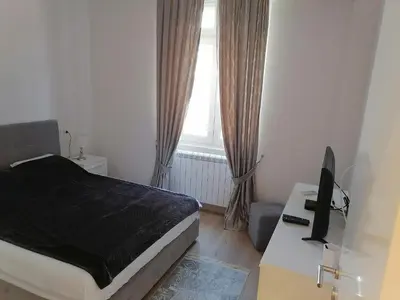 a bedroom with a bed and a desk with a television at Beograd centar in Belgrade