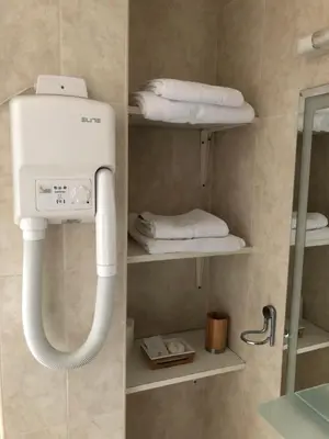 a bathroom with a white towel rack and towels at Hotel Topcider in Belgrade