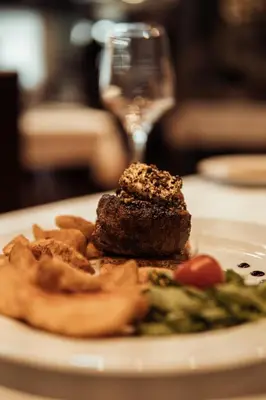 a plate of food with meat and vegetables on a table at Hotel Topcider in Belgrade