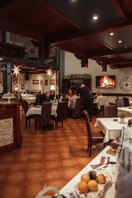 a restaurant with tables and chairs and people sitting at tables at Hotel Topcider in Belgrade