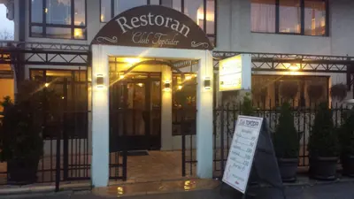 a restaurant with a sign in front of a building at Hotel Topcider in Belgrade