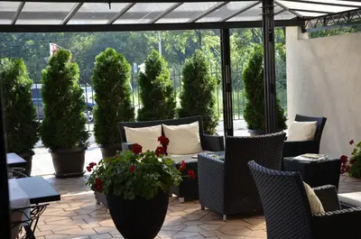 a patio with chairs and tables and potted plants at Hotel Topcider in Belgrade