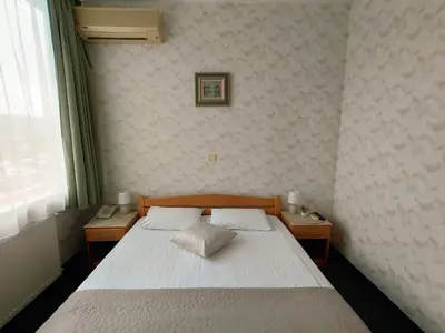 a bedroom with a white bed with two night stands at Hotel Slodes in Belgrade