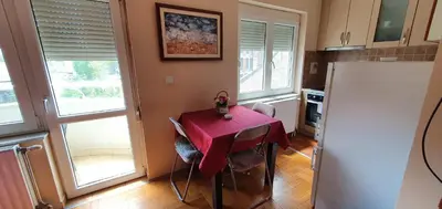 a kitchen with a table with a red table cloth on it at Julija 2 in Pančevo