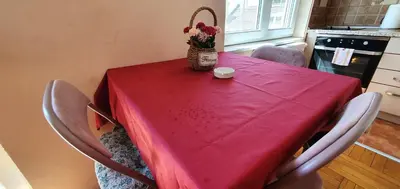 a table with a red table cloth and a bowl of flowers on it at Julija 2 in Pančevo